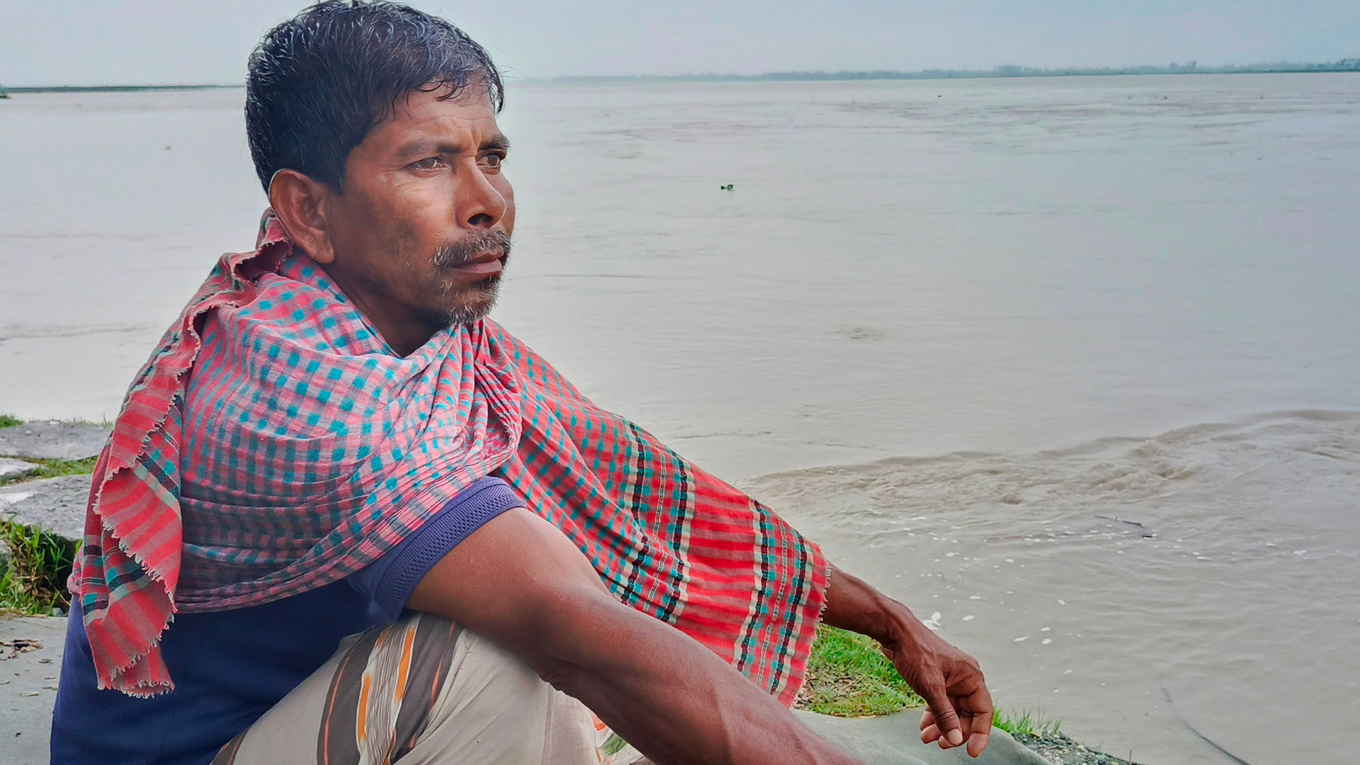 তিস্তা নদের পাড়ে বসে আছেন এক কৃষক