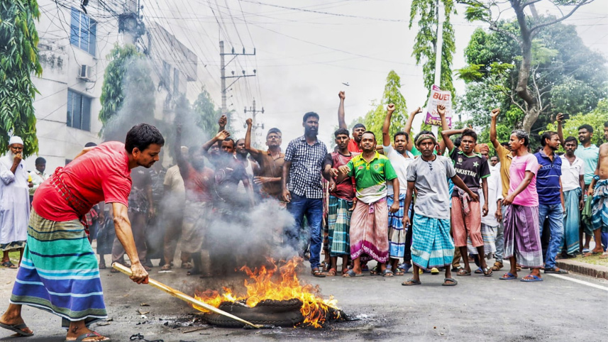 টায়ারে আগুন জ্বালিয়ে মহাসড়ক অবরোধ করে বিক্ষোভ করেন পাট শ্রমিকেরা। ছবি: স্টার