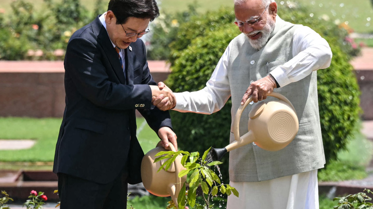 দক্ষিণ কোরিয়ার প্রেসিডেন্ট লি জায়ে মিউংকে সঙ্গে নিয়ে ফুল গাছে পানি দিচ্ছেন ভারতের প্রধানমন্ত্রী মোদি। ছবি: রয়টার্স